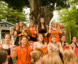 Campers dressed in black and orange sing camp songs.