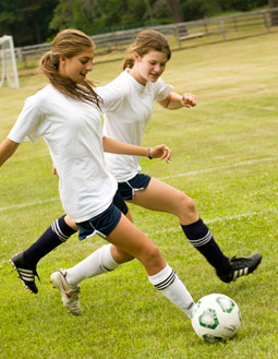 Two campers vying for the ball in Soccer.